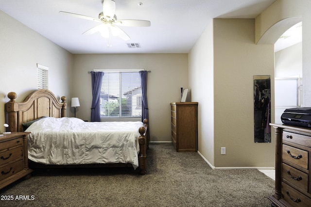 carpeted bedroom featuring arched walkways, baseboards, visible vents, and ceiling fan