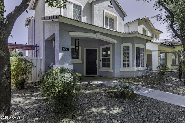 doorway to property with a porch and stucco siding