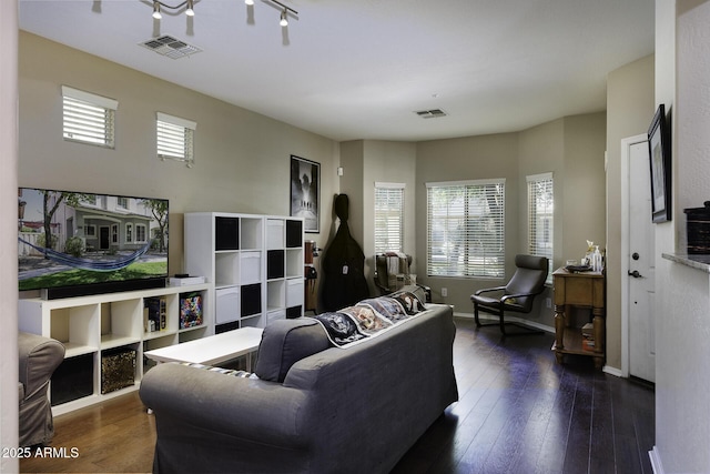 living area with baseboards, hardwood / wood-style flooring, and visible vents