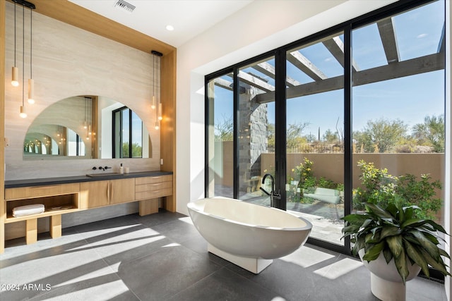 bathroom featuring vanity, backsplash, and a bathing tub