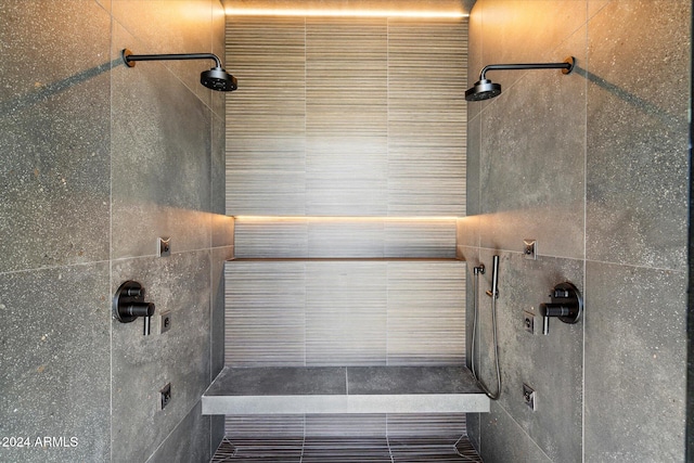 bathroom with tiled shower and tile walls