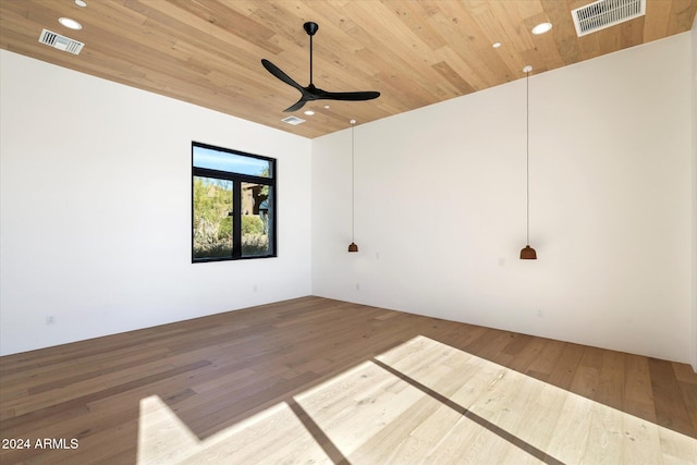 spare room featuring wooden ceiling, wood finished floors, and visible vents