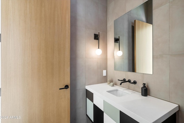 bathroom featuring vanity and tile walls