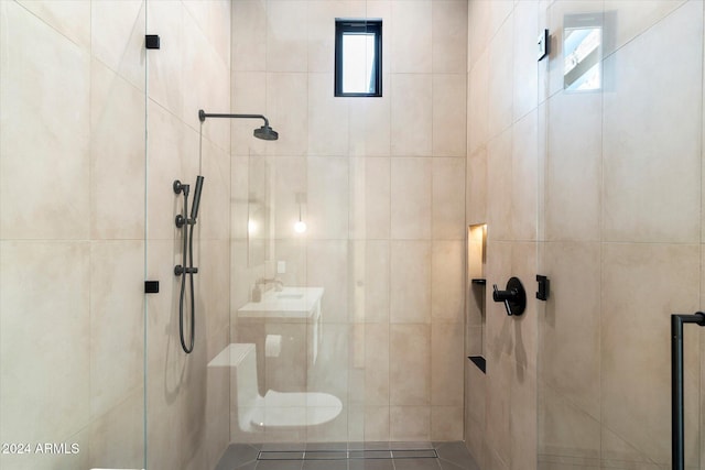 bathroom with a tile shower and a wealth of natural light