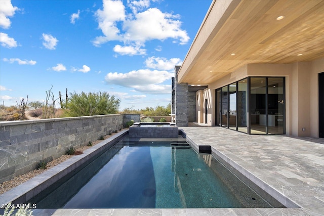 view of swimming pool with a patio area and a pool with connected hot tub