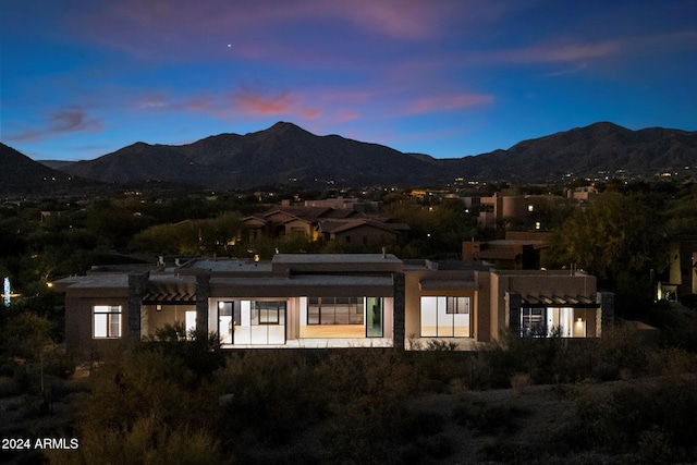 back of property at dusk with a mountain view