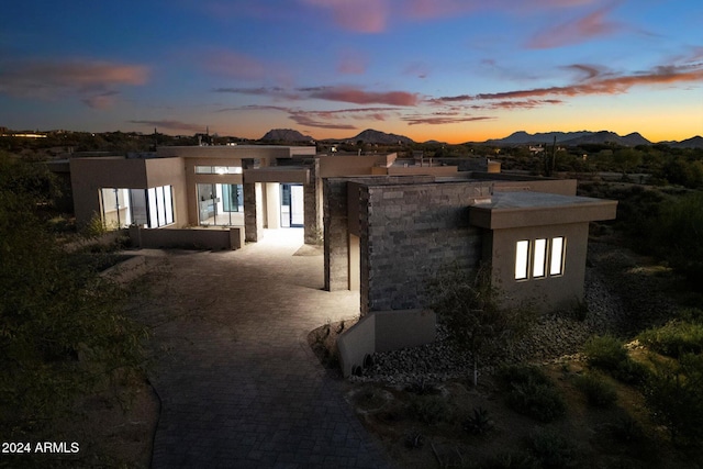 view of home's exterior with a mountain view, a patio, and stucco siding