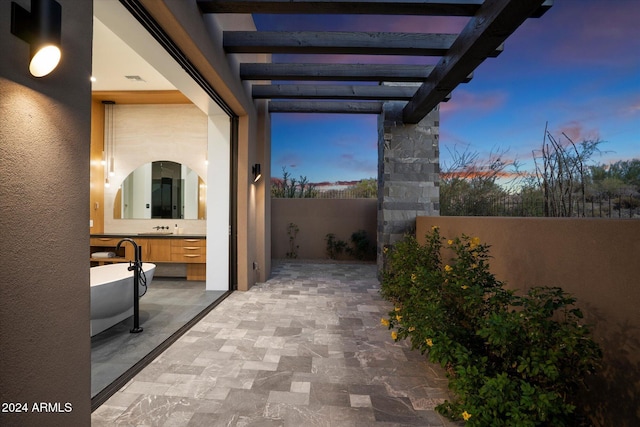 patio terrace at dusk featuring sink