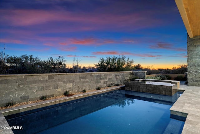 pool at dusk featuring an outdoor pool