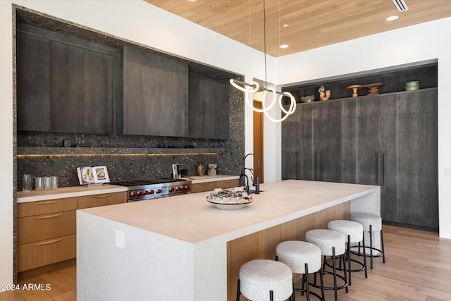 kitchen featuring pendant lighting, light countertops, high end range, and modern cabinets