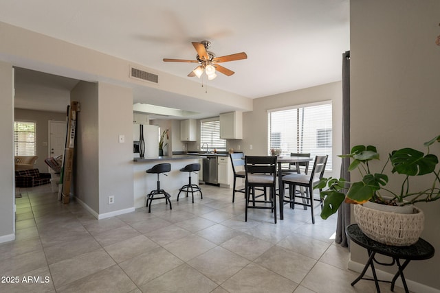 2455 E Broadway Rd Unit 115, Mesa, AZ 85204 - dining area featuring ceiling fan, light tile patterned floors, and baseboards