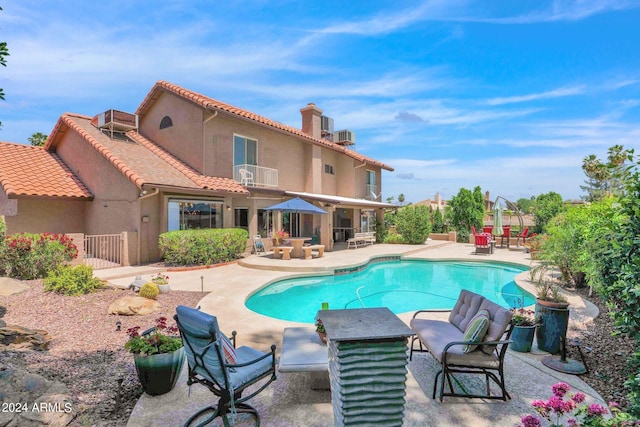 pool featuring cooling unit, a patio area, and fence