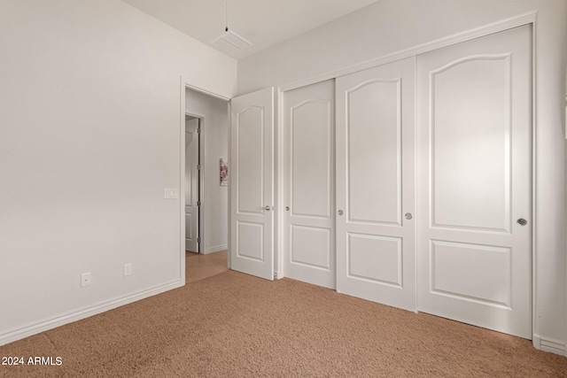 unfurnished bedroom featuring carpet and a closet