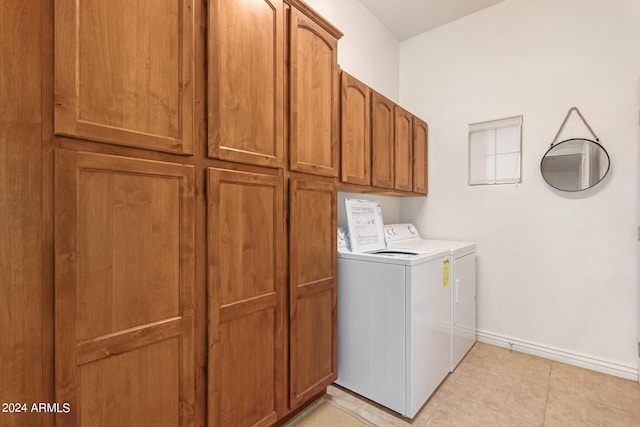 laundry area with light tile patterned floors, cabinets, and separate washer and dryer