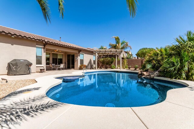 view of swimming pool featuring area for grilling, a pergola, and a patio area