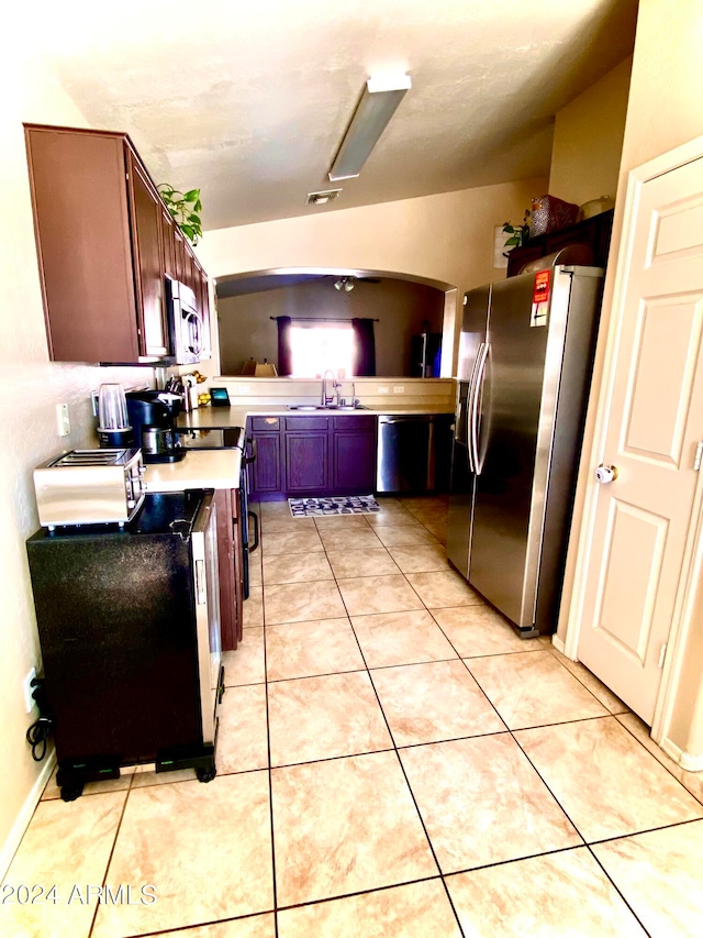 kitchen featuring light tile patterned floors, stainless steel appliances, and sink