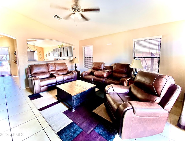 living room with lofted ceiling, light tile patterned flooring, and ceiling fan