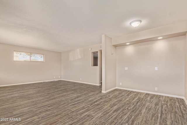 below grade area with dark wood-type flooring, recessed lighting, and baseboards