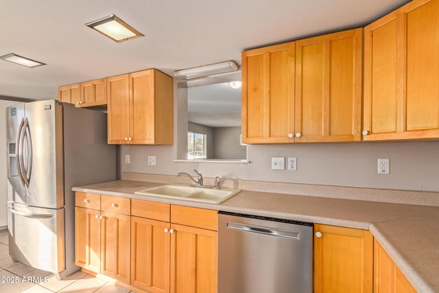 kitchen with light tile patterned flooring, stainless steel appliances, a sink, and light countertops