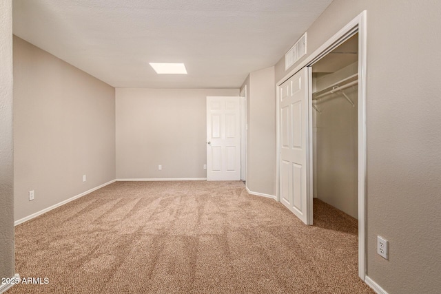 unfurnished bedroom featuring carpet floors, baseboards, visible vents, and a closet