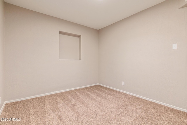 carpeted spare room featuring baseboards