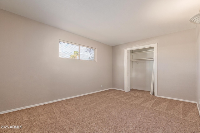 unfurnished bedroom with light carpet, a closet, and baseboards