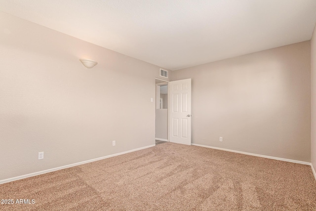 empty room with carpet flooring, visible vents, and baseboards