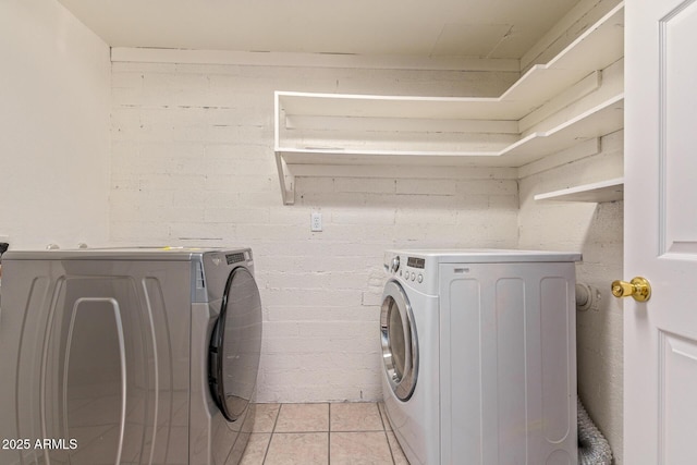 washroom featuring laundry area, independent washer and dryer, and light tile patterned floors