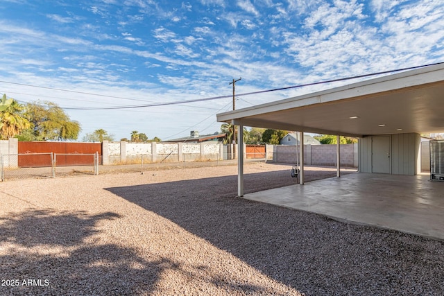 view of yard featuring a patio area, a fenced backyard, and a carport