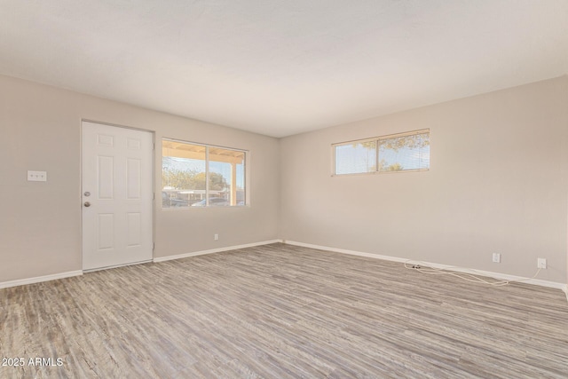 spare room with wood finished floors and baseboards