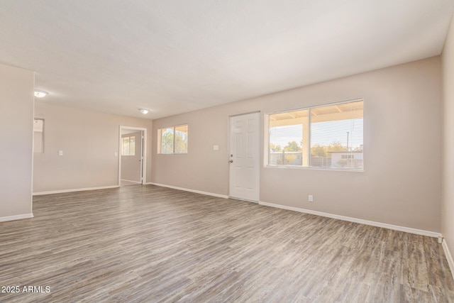 unfurnished room featuring baseboards and wood finished floors