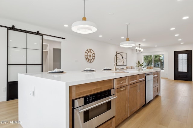8403 E Fairmount Ave, Scottsdale, AZ 85251 - kitchen with appliances with stainless steel finishes, a large island with sink, light wood-type flooring, recessed lighting, and pendant lighting