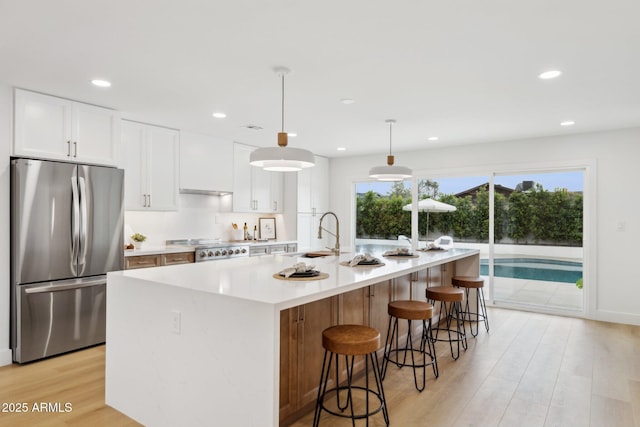 8403 E Fairmount Ave, Scottsdale, AZ 85251 - kitchen featuring freestanding refrigerator, a sink, white cabinets, light wood finished floors, and a large island