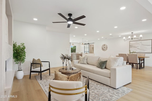 8403 E Fairmount Ave, Scottsdale, AZ 85251 - living room with a barn door, light wood-style flooring, recessed lighting, ceiling fan, and a chandelier