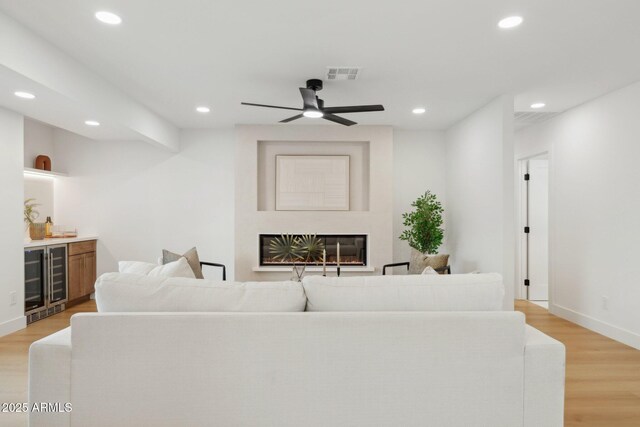 8403 E Fairmount Ave, Scottsdale, AZ 85251 - living area with beverage cooler, a bar, recessed lighting, light wood-style floors, and baseboards