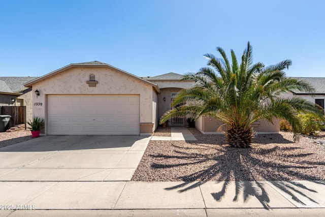 view of front of home with concrete driveway, fence, an attached garage, and stucco siding