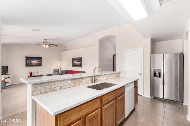 kitchen with light tile patterned floors, open floor plan, a sink, stainless steel fridge, and dishwasher