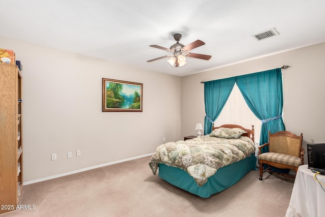 carpeted bedroom featuring a ceiling fan, visible vents, and baseboards