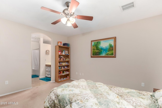 bedroom with arched walkways, ceiling fan, light carpet, visible vents, and baseboards