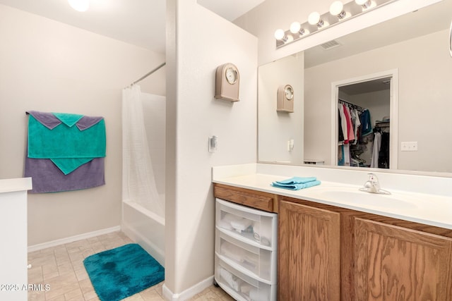 full bathroom with shower / tub combo with curtain, visible vents, a spacious closet, vanity, and baseboards