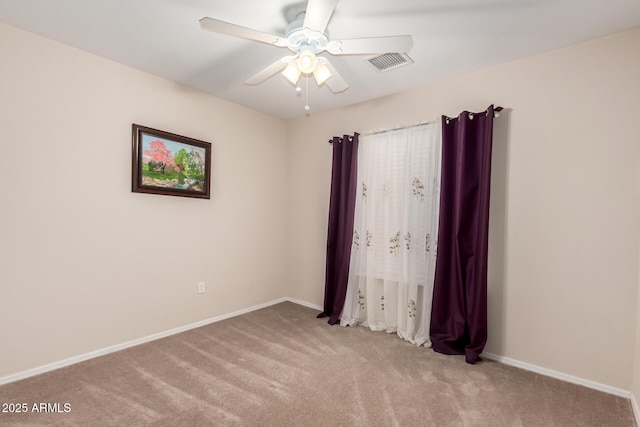 spare room with baseboards, carpet, visible vents, and a ceiling fan