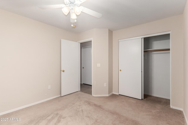 unfurnished bedroom featuring ceiling fan, baseboards, a closet, and light colored carpet