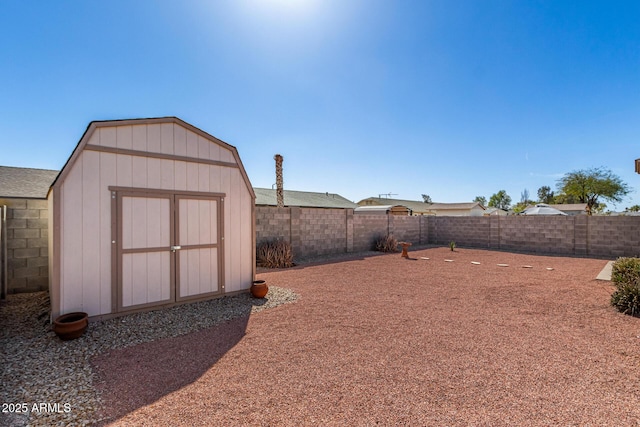 exterior space with an outbuilding, a fenced backyard, and a shed