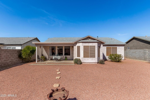 back of house with a patio area, a fenced backyard, roof with shingles, and stucco siding