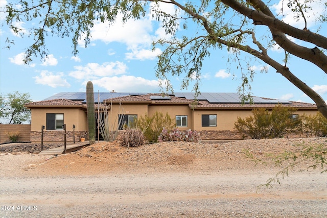 view of front of property featuring solar panels