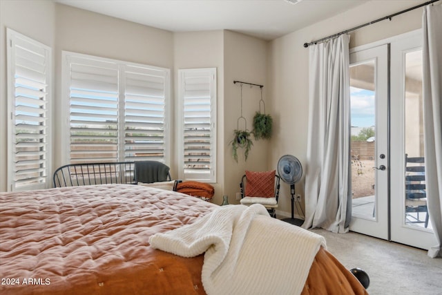 bedroom with french doors, multiple windows, access to outside, and carpet