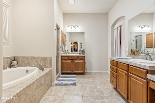 bathroom with tile patterned flooring, vanity, and plus walk in shower