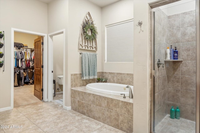 bathroom with toilet, shower with separate bathtub, and tile patterned floors