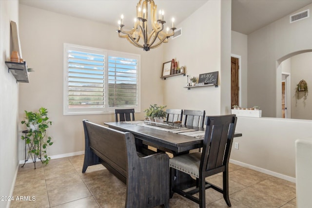 dining space featuring lofted ceiling, light tile patterned floors, and a notable chandelier