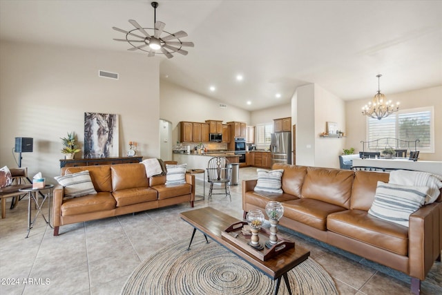 tiled living room featuring vaulted ceiling and ceiling fan with notable chandelier